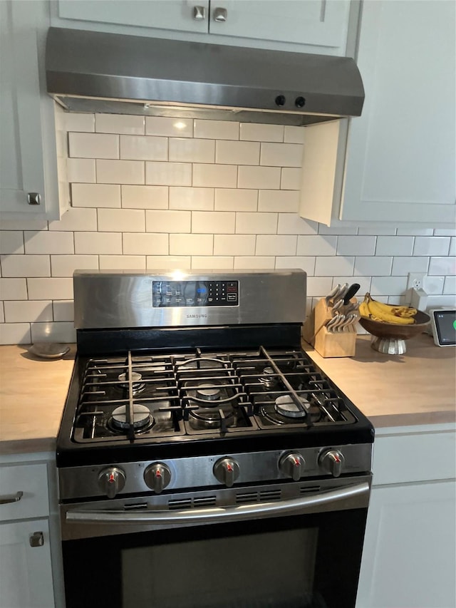 kitchen featuring wood counters, decorative backsplash, and stainless steel range with gas cooktop