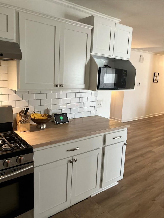 kitchen with backsplash, stainless steel gas range, butcher block countertops, and white cabinets