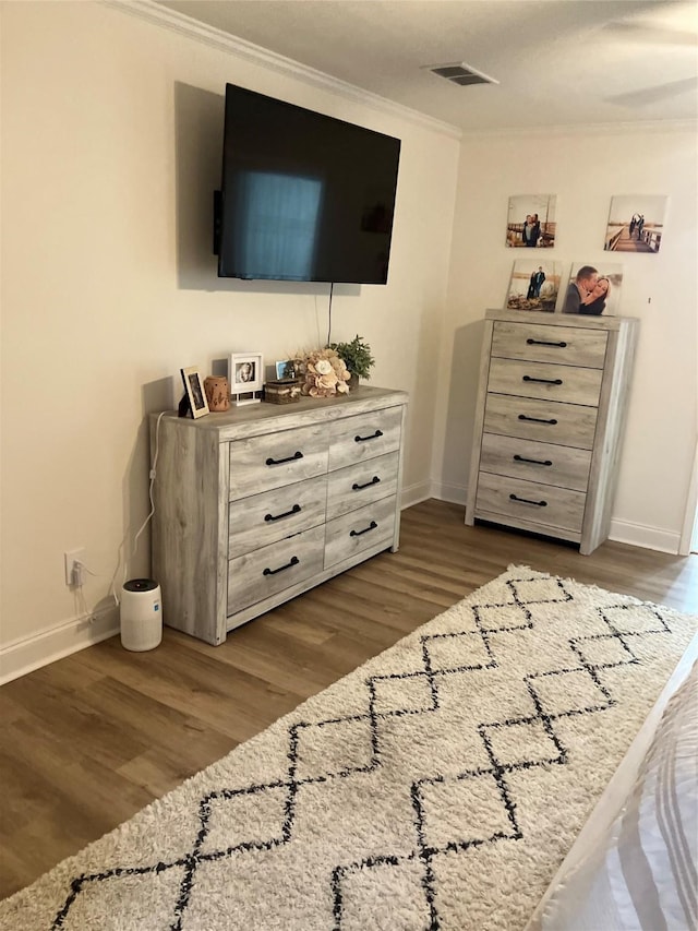 bedroom with dark wood-type flooring and ornamental molding