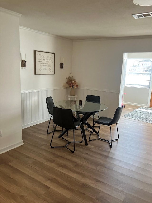 dining space with dark wood-type flooring and crown molding