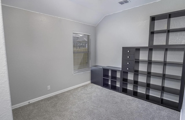 carpeted spare room with lofted ceiling