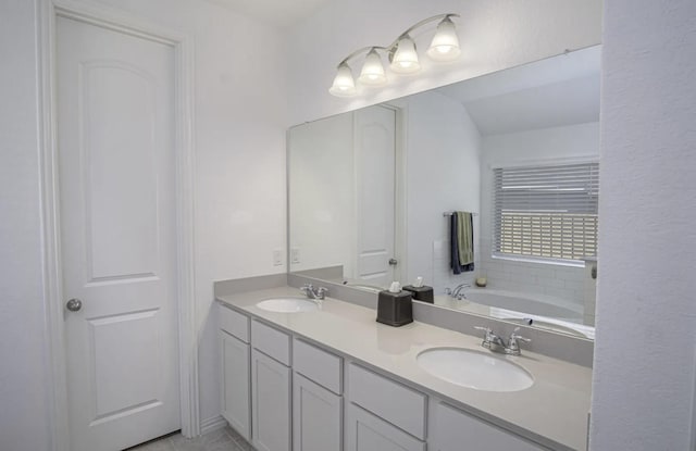 bathroom featuring a tub, vanity, and tile patterned flooring