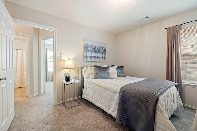 bedroom with light carpet, visible vents, and baseboards