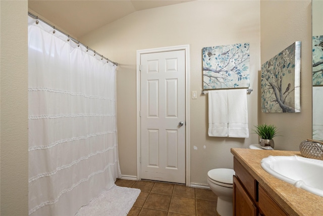 bathroom with vaulted ceiling, toilet, tile patterned flooring, and vanity