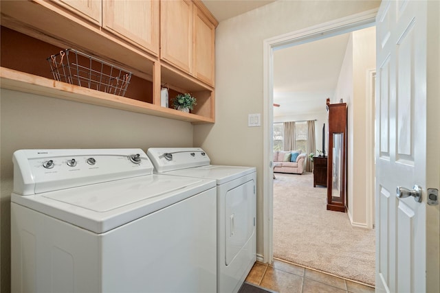 laundry room with light carpet, cabinet space, light tile patterned floors, baseboards, and washer and dryer