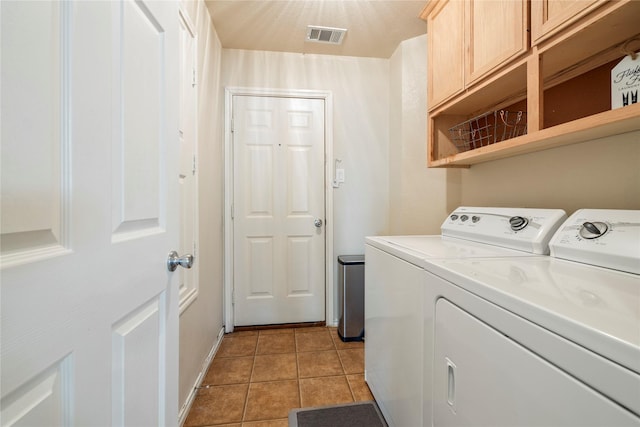 washroom with cabinet space, light tile patterned floors, baseboards, visible vents, and separate washer and dryer