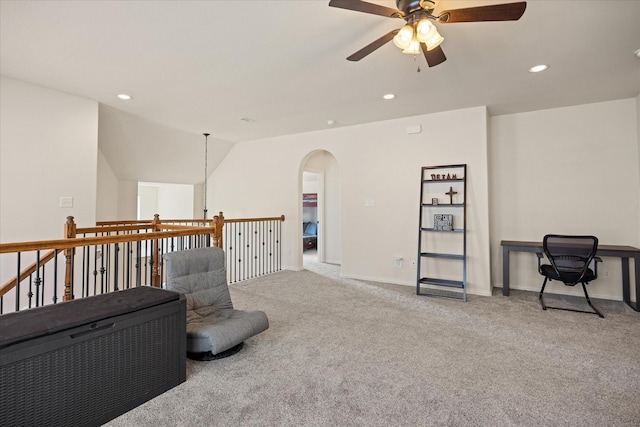 living area featuring ceiling fan, light colored carpet, and lofted ceiling