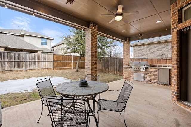 view of patio featuring ceiling fan, a grill, and exterior kitchen