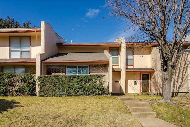 townhome / multi-family property featuring a front lawn