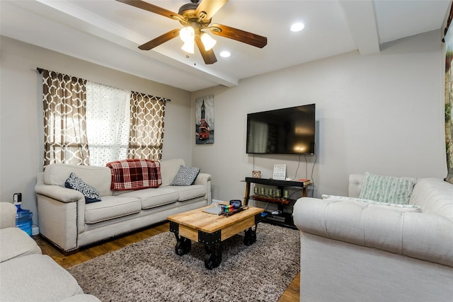 living room featuring ceiling fan, beam ceiling, and dark hardwood / wood-style floors