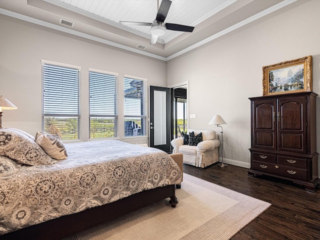 bedroom featuring ceiling fan, a raised ceiling, dark hardwood / wood-style floors, and crown molding