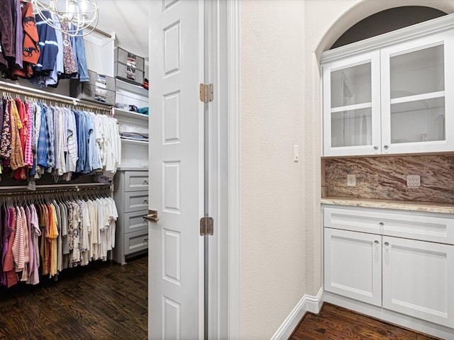 walk in closet with dark hardwood / wood-style flooring