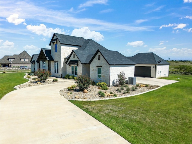 french country inspired facade featuring a front lawn, a garage, and central AC