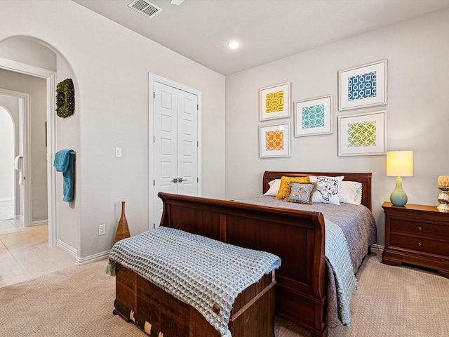 bedroom featuring light colored carpet and a closet