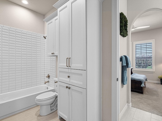 bathroom with tile patterned floors, toilet, and shower / washtub combination