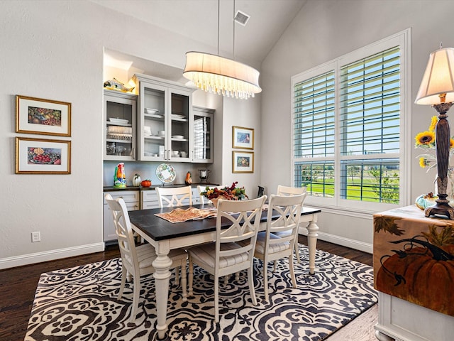 dining area featuring dark wood-type flooring and lofted ceiling