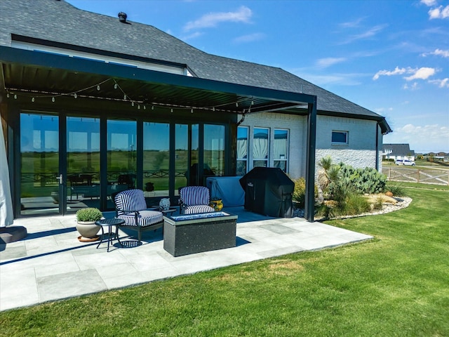 rear view of property featuring a lawn, a fire pit, and a patio