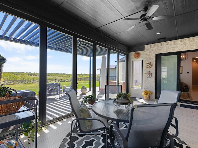 sunroom / solarium featuring ceiling fan and wooden ceiling