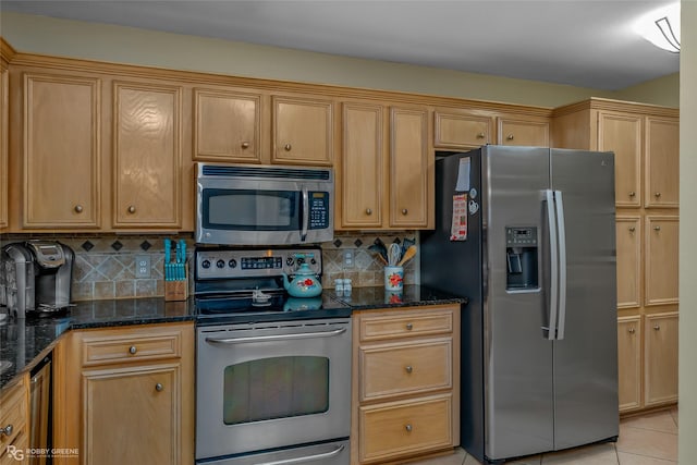 kitchen featuring light tile patterned flooring, stainless steel appliances, dark stone counters, and tasteful backsplash