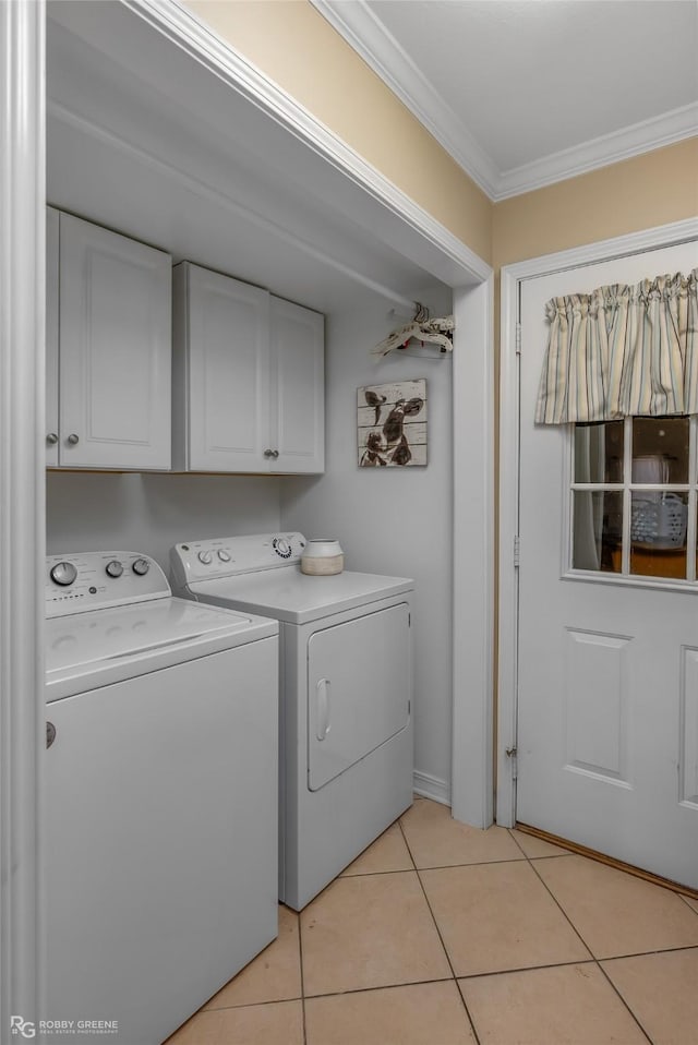 laundry area with light tile patterned floors, independent washer and dryer, crown molding, and cabinets