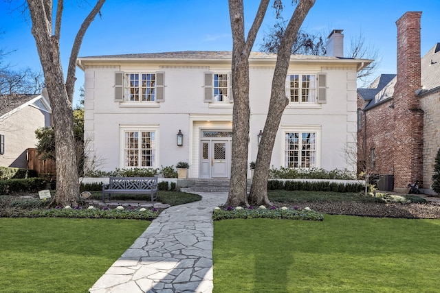 colonial inspired home featuring a front yard and central air condition unit