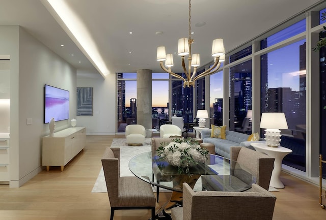 dining area with light hardwood / wood-style floors, expansive windows, and a chandelier