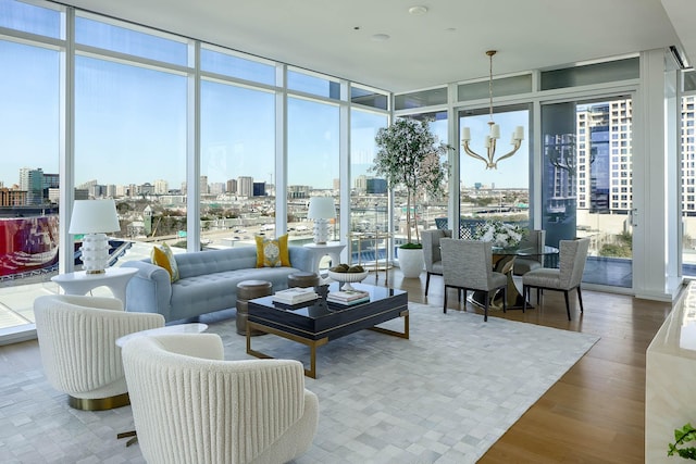 living room with a wealth of natural light, a wall of windows, and hardwood / wood-style floors