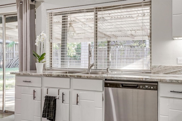 kitchen featuring light stone countertops, white cabinetry, dishwasher, and sink