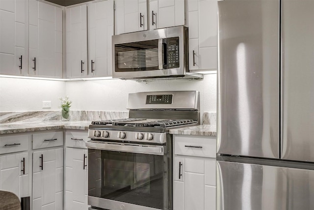 kitchen featuring light stone counters, white cabinets, and appliances with stainless steel finishes