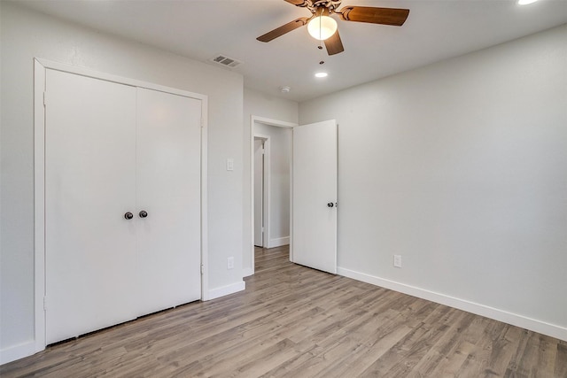 unfurnished bedroom with ceiling fan, a closet, and light wood-type flooring