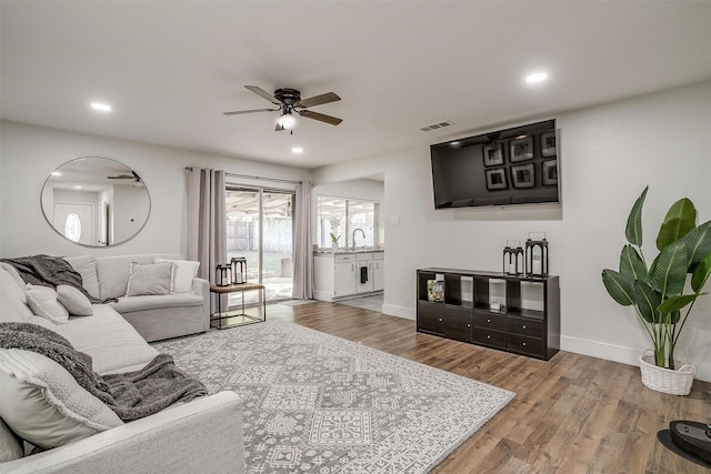 living room with ceiling fan, sink, and hardwood / wood-style floors