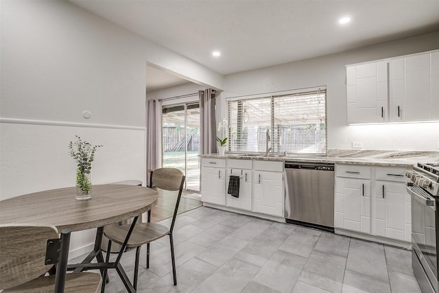 kitchen with light stone counters, sink, white cabinets, and appliances with stainless steel finishes