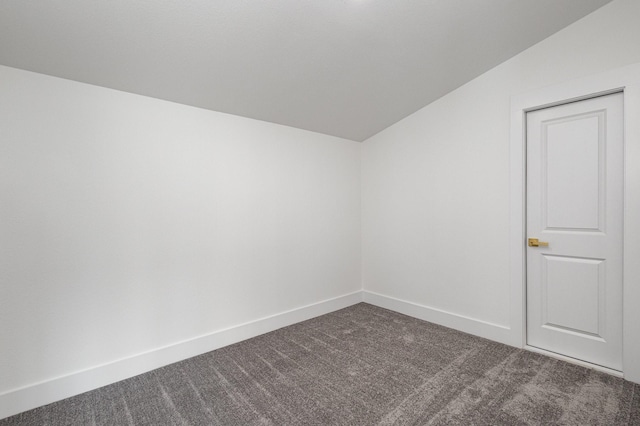 carpeted spare room with vaulted ceiling