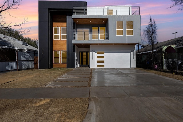 contemporary house with a garage and a balcony