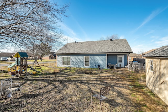 rear view of property featuring a yard and a playground