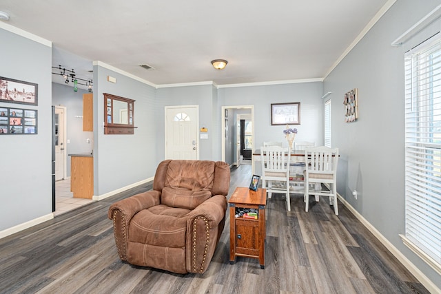 living room featuring dark hardwood / wood-style floors, ornamental molding, and a barn door