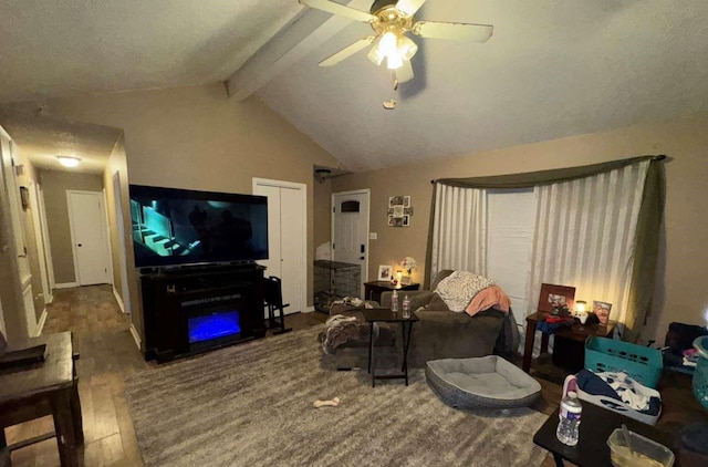 living room with ceiling fan, a textured ceiling, hardwood / wood-style flooring, and vaulted ceiling with beams