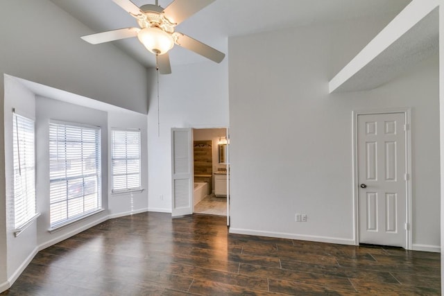 unfurnished room with ceiling fan and high vaulted ceiling