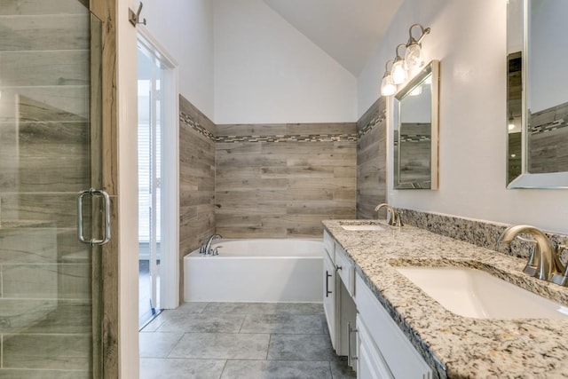 bathroom featuring vanity, vaulted ceiling, and independent shower and bath