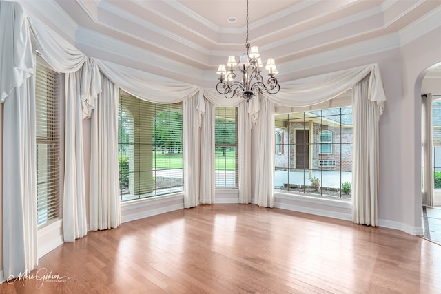 interior space featuring a raised ceiling and a chandelier