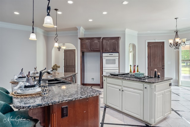 9356 Dogwood Trl, Haughton, LA 71037 - kitchen featuring stainless steel gas cooktop, arched walkways, a sink, and a kitchen island