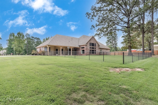 rear view of property featuring a lawn