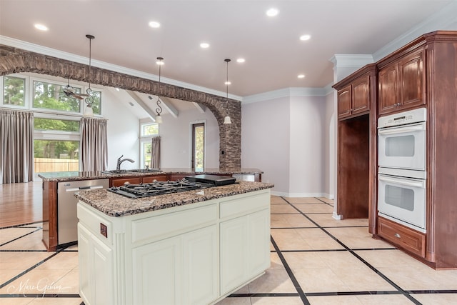 kitchen featuring a center island, stainless steel appliances, sink, hanging light fixtures, and light tile patterned floors