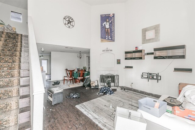 interior space with a fireplace, a towering ceiling, and hardwood / wood-style flooring