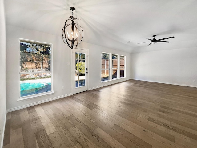 unfurnished living room featuring vaulted ceiling, dark wood-type flooring, and ceiling fan with notable chandelier