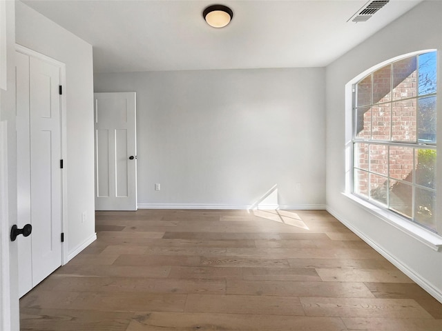 unfurnished room with hardwood / wood-style flooring