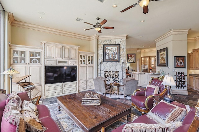 living room featuring ornamental molding and a stone fireplace