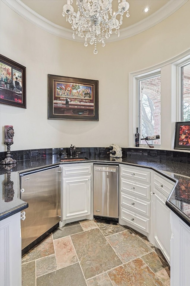 kitchen featuring ornamental molding, white cabinets, dishwasher, and a sink