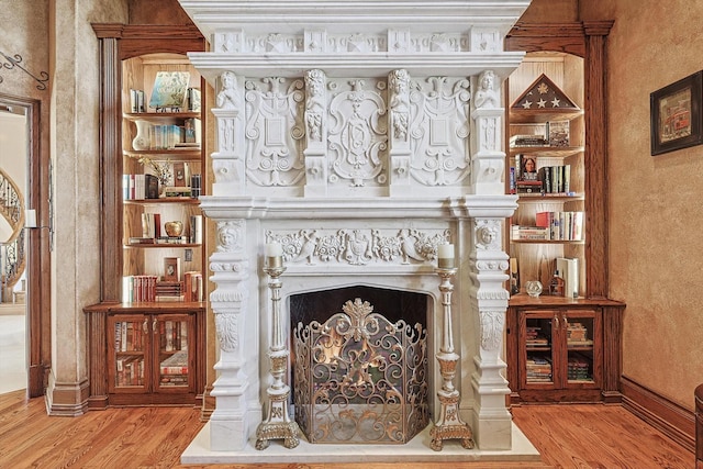 living area with built in shelves and light wood-type flooring