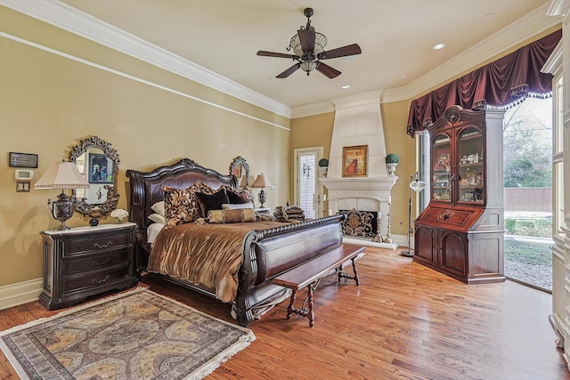 bedroom with access to outside, ceiling fan, a fireplace, and light wood-type flooring